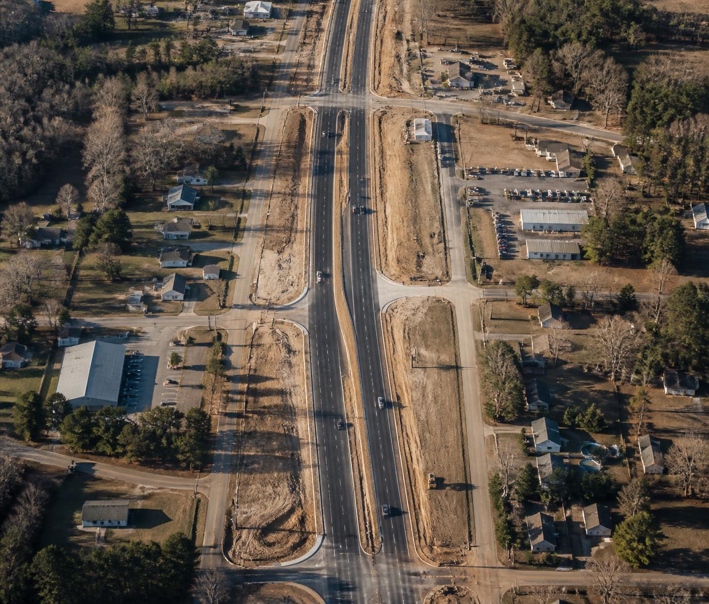 Aerial view of a roadway widening project passing through residential and commercial parcels